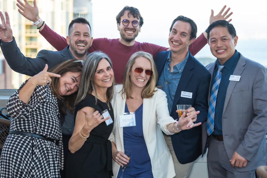 Priceline team members celebrating at rooftop portrait studio during General Conference in San Francisco.