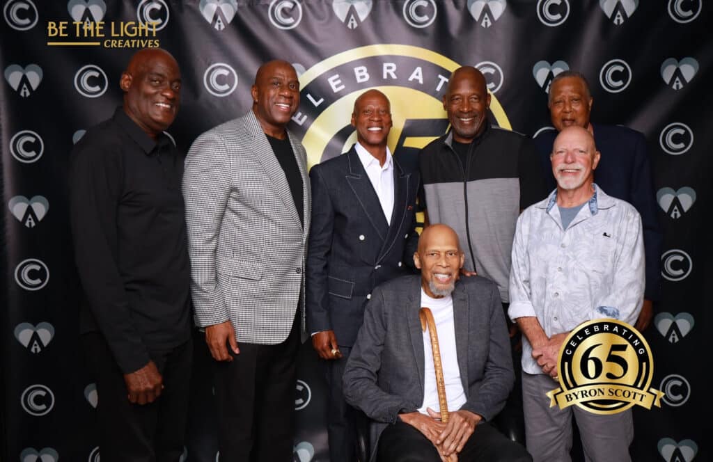 Byron Scott and Lakers legends on red carpet step-and-repeat at birthday celebration.