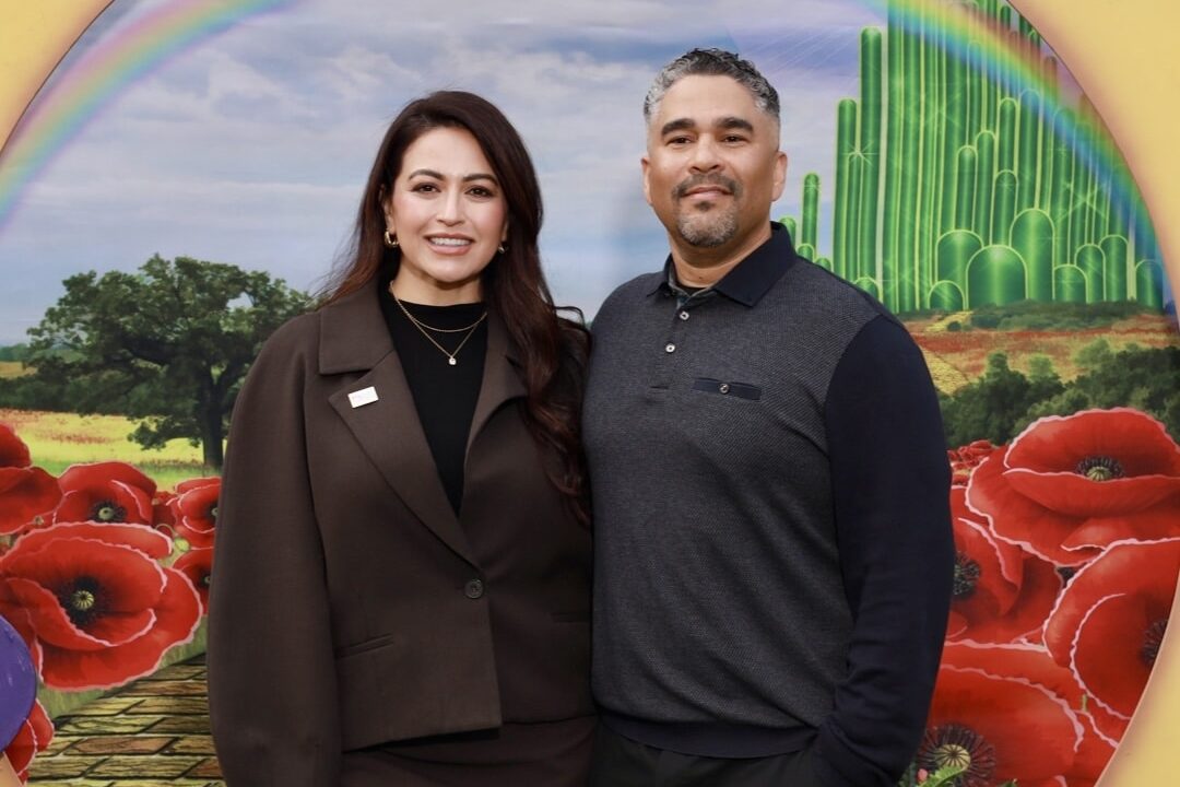 couple posing in front of a colorful corporate custom backdrop